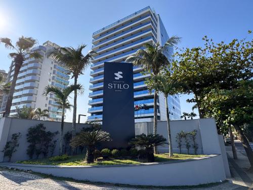 a sign in front of a building with palm trees at Laghetto Stilo Barra in Rio de Janeiro