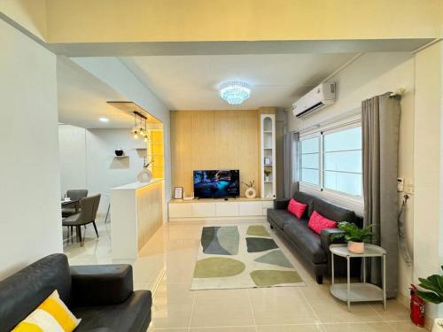 a living room with a couch and a tv at MIQ HK256 5BR MRT Ratchada and HuaiKhwang in Bangkok