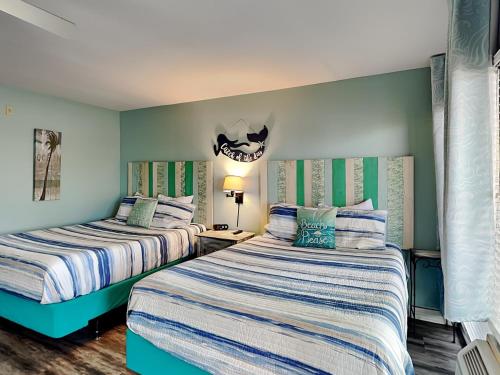 zwei Betten in einem Zimmer mit blauen Wänden in der Unterkunft Laguna Reef #121 - Gone Coastal in Rockport
