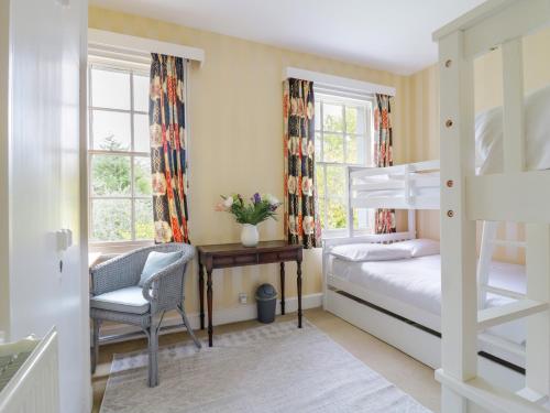 a bedroom with a bunk bed and a chair at Rough Hill House in Chelmsford