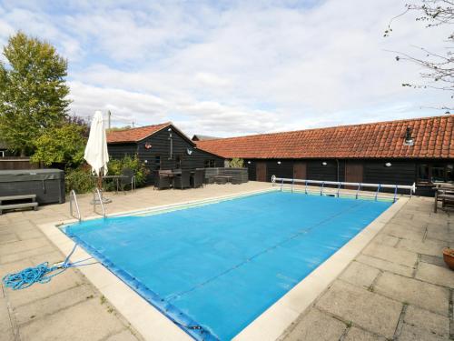 a swimming pool in a courtyard with a house at Rough Hill House in Chelmsford