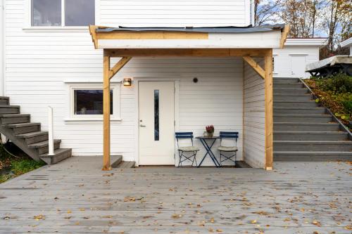 a garage with two chairs and a table on a patio at Håkøyveien 151, Tromsø in Tromsø