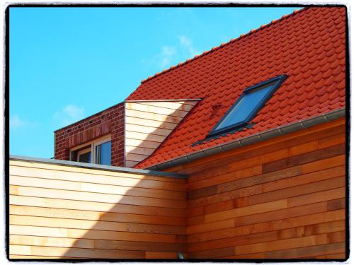 a house with a red roof with two windows at Archipel Holiday Cottage in Ellezelles