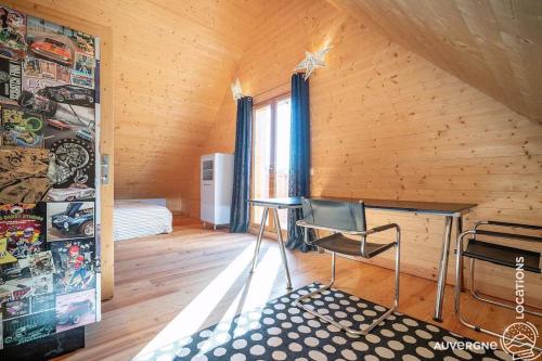 Cette chambre comprend un lit et une chaise. dans l'établissement Le Résal, à Murol