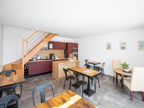 Un restaurante con mesas y sillas y una cocina. en Manoir de Turqueville les Quatre Etoiles, en Turqueville