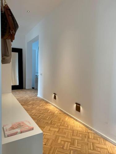 a room with a white wall and a wooden floor at Appartement neuf en plein centre in Namur