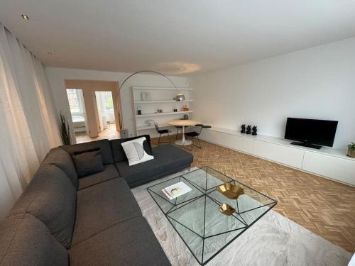 a living room with a couch and a glass table at Appartement neuf en plein centre in Namur