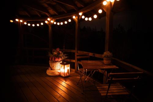 a wooden deck with lights and a table and a table sidx sidx sidx at Treehouseestonia in Jõgisoo