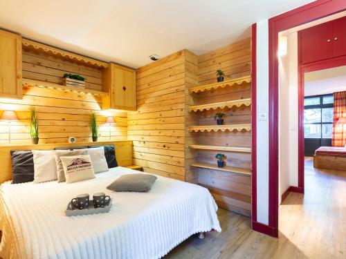 une chambre avec un lit dans une pièce aux murs en bois dans l'établissement Appartement rénové avec sauna, piscine, et parking à Saint Lary Village - 4 pers - FR-1-296-371, à Saint-Lary-Soulan