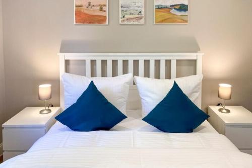 a bedroom with a white bed with blue pillows at Haus Wellenrauschen in Zingst