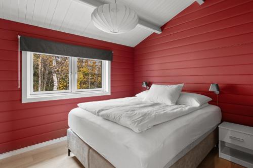 a red bedroom with a bed and a window at Håkøyveien 151, Tromsø in Tromsø