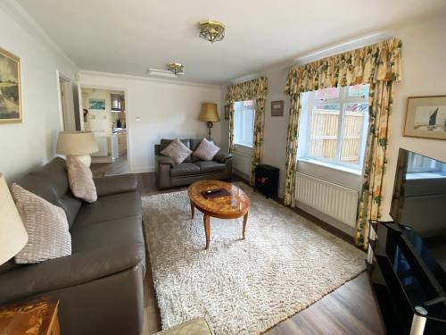 a living room with a couch and a table at Garden Cottage in Great Yarmouth
