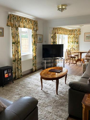 a living room with a tv and a coffee table at Garden Cottage in Great Yarmouth