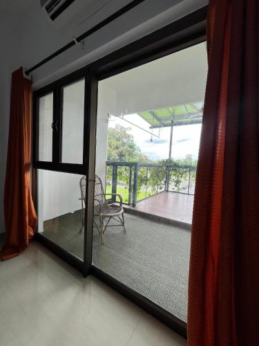 a room with a window and a chair on a balcony at River View Resort by Periyar Ayurveda in Kodanad