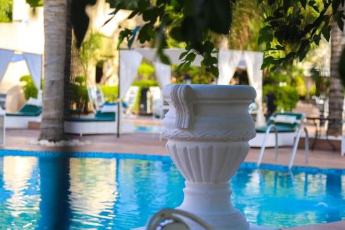 a white vase sitting next to a swimming pool at Weedan Hôtel&Spa Marrakech in Oulad Snaguia