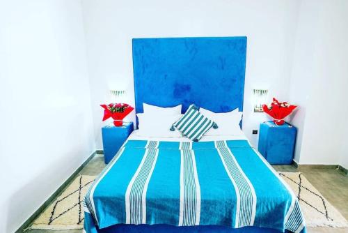 a blue and white bed in a room with two blue vases at Weedan Hôtel&Spa Marrakech in Oulad Snaguia