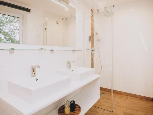 a white bathroom with a sink and a shower at Appartements Prielau by we rent, SUMMERCARD INCLUDED in Zell am See