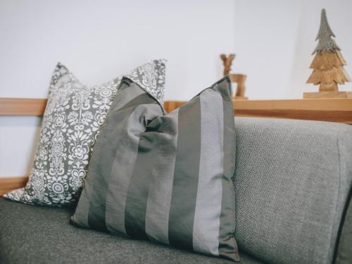 two pillows on a couch with a christmas tree in the background at Appartements Prielau by we rent, SUMMERCARD INCLUDED in Zell am See