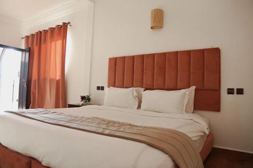 a bedroom with a large bed with a large headboard at Weedan Hôtel&Spa Marrakech in Oulad Snaguia