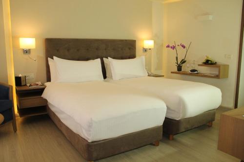 a bedroom with a large bed with white sheets and pillows at InterContinental Mzaar Lebanon Mountain Resort & Spa by IHG in Kfardebian
