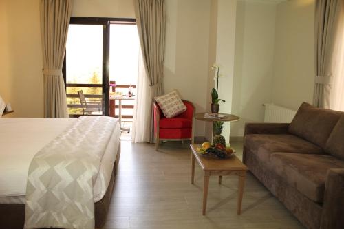 a hotel room with a bed and a couch at InterContinental Mzaar Lebanon Mountain Resort & Spa by IHG in Kfardebian