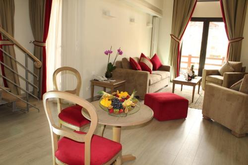 a living room with a table with flowers on it at InterContinental Mzaar Lebanon Mountain Resort & Spa by IHG in Kfardebian