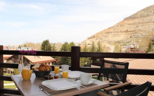 a table on a balcony with a view of a mountain at InterContinental Mzaar Lebanon Mountain Resort & Spa by IHG in Kfardebian