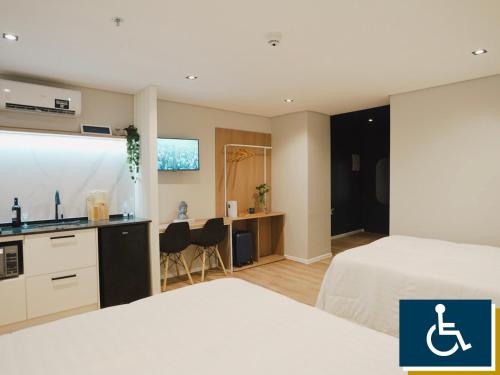 a hotel room with two beds and a sink and a kitchen at Apê Brás - Shopping Plaza Polo in Sao Paulo