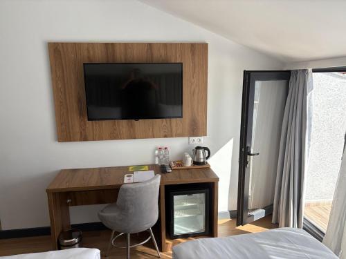 イスタンブールにあるBusiness Life Hotel Güneşliのベッドルーム(デスク、壁掛けテレビ付)