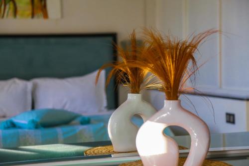 two white vases with plants in them on a table at Weedan Hôtel&Spa Marrakech in Oulad Snaguia
