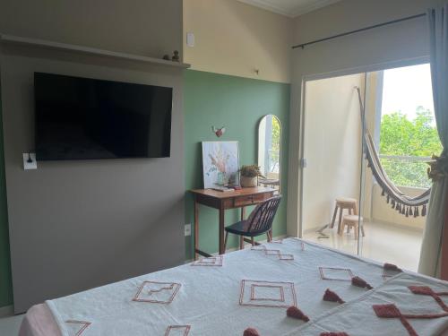 a bedroom with a bed and a desk and a television at Flat Ilha Bela 22525 in Alter do Chao