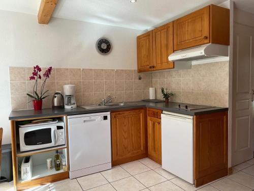 - une cuisine avec des placards en bois et des appareils blancs dans l'établissement Chalet Margot 20, à Saint-Étienne-en-Dévoluy