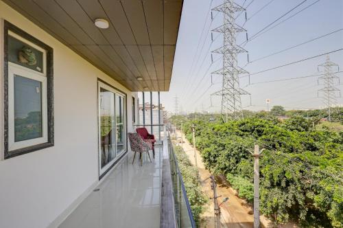 a balcony of a house with a red chair on it at Limewood Stay Oasis - Golf Course Road in Gurgaon