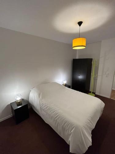 - une chambre avec un lit blanc et une lumière jaune dans l'établissement logement moderne ambiance led personnalisable, à Stains