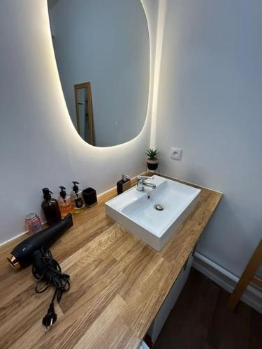 une salle de bain avec un lavabo blanc et un miroir dans l'établissement logement moderne ambiance led personnalisable, à Stains