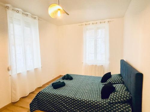 une chambre avec un lit et deux fenêtres dans l'établissement Charmant 2 pièces rénové, à Strasbourg