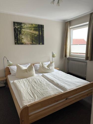 a bedroom with a large bed with white sheets and pillows at Gasthof Kreisi in Friedberg