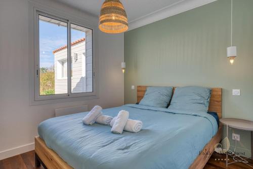une chambre avec un grand lit avec des serviettes dessus dans l'établissement Maison familiale piscine chauffée Jardin d'Océan, à Bretignolles-sur-Mer