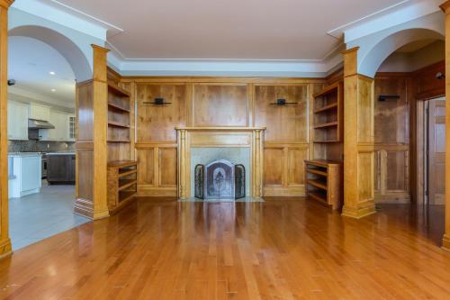 an empty living room with a fireplace and wooden walls at Lux Waterfront Private 4bd home in Saint John