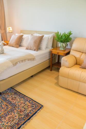 a bed and a chair in a room at Green Me Organic Farm Khao Yai กรีนมี ออแกนิคฟาร์ม เขาใหญ่ in Ban Khlong Yang