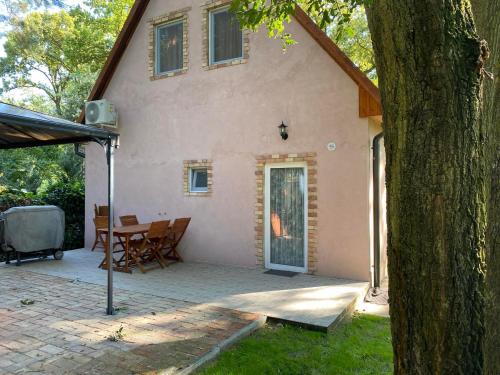 a house with a table and chairs in front of it at Irány Horány Vendégház in Szigetmonostor