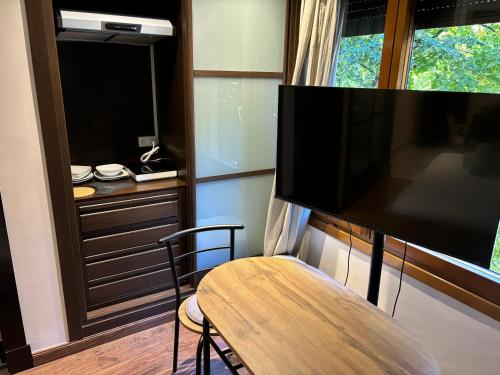 a room with a tv and a table and a chair at Las Estrellas de Soria in Soria