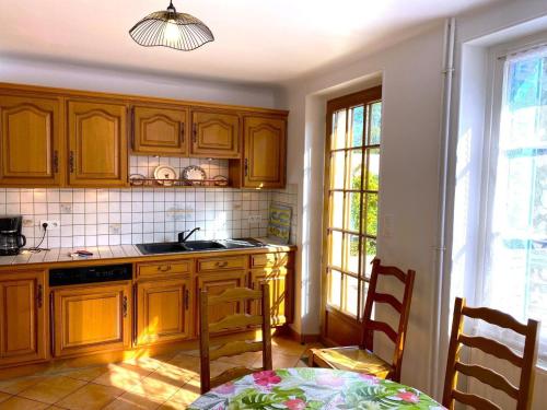 a kitchen with wooden cabinets and a table and chairs at Melabelle in Malandry