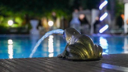 a statue of a bird sitting next to a pool at Weedan Hôtel&Spa Marrakech in Oulad Snaguia