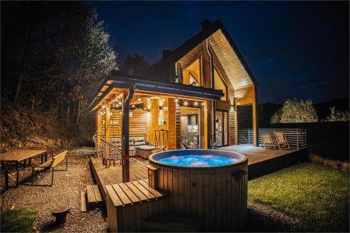 a large hot tub in front of a log cabin at CzillChata - dom z balią in Maków Podhalański