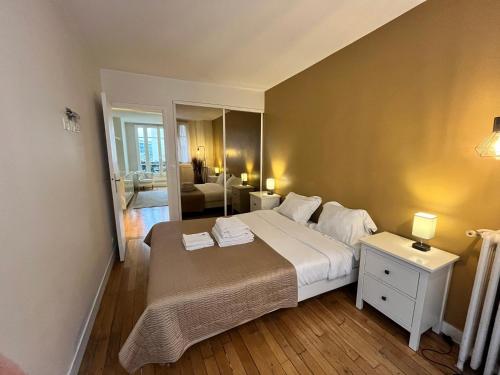 a bedroom with a large bed and a living room at Superbe Appartement 2P PARIS Boulogne Roland Garros in Boulogne-Billancourt