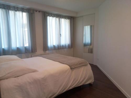 - une chambre avec un lit blanc et 2 fenêtres dans l'établissement LE DOUILLET - Parking gratuit - Centre ville, à Pau