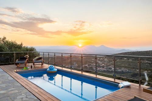 a pool with a view of the mountains at sunset at Martinia Pool Getaways - Majestic Panoramic Views in Áno Ámfia