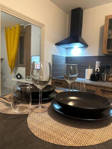 - une table avec une assiette et des verres à vin dans l'établissement Loco Parc Duplex, à Dijon
