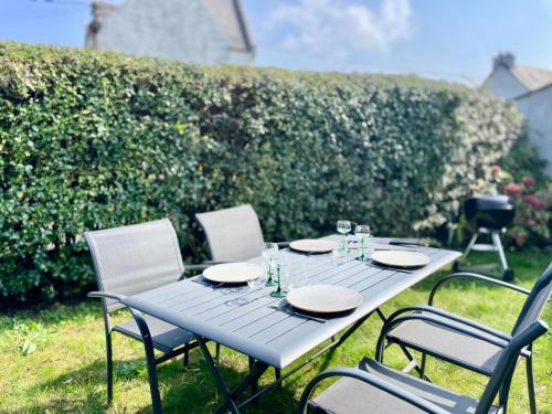 a picnic table with plates and glasses on it at Charmante maison de pêcheur in Carantec